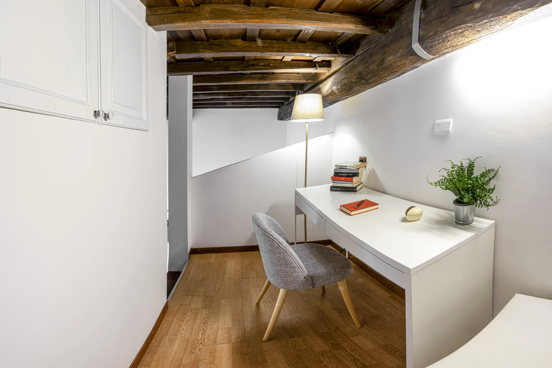 Zona studio sotto il soffitto con travi a vista